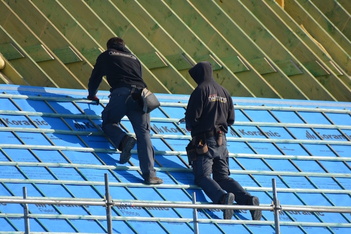 Expertos instaladores colocando canaletas pluviales empotradas